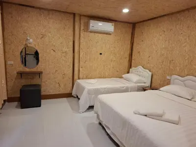 a hotel room with two beds and a mirror at ฟาดิลบังกะโล Fadel bungalow in Ko Nui