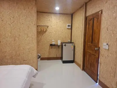 a room with a bed and a refrigerator in it at ฟาดิลบังกะโล Fadel bungalow in Ko Nui