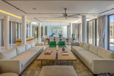 a living room with white couches and a table at Villa Amarasara in Phuket Town