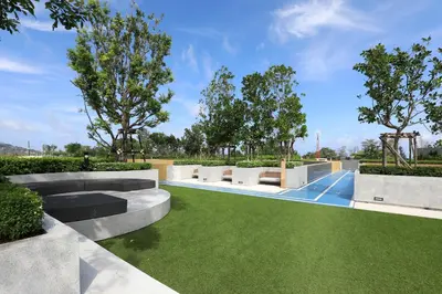 a garden with benches and green grass at New 1 bdr Apartment in Laguna 50m from the Beach in Bang Tao Beach