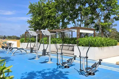 a row of exercise equipment on the side of a pool at New 1 bdr Apartment in Laguna 50m from the Beach in Bang Tao Beach