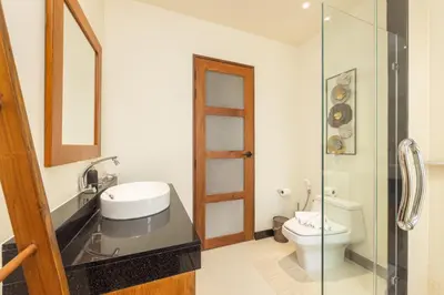 a bathroom with a toilet and a glass shower at Villa Emilia Private Pool Naiharn in Rawai Beach