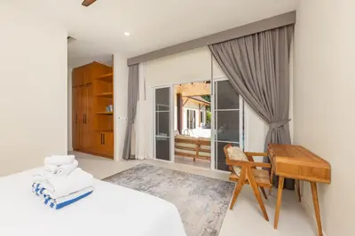a bedroom with a bed and a desk and a table at Villa Emilia Private Pool Naiharn in Rawai Beach