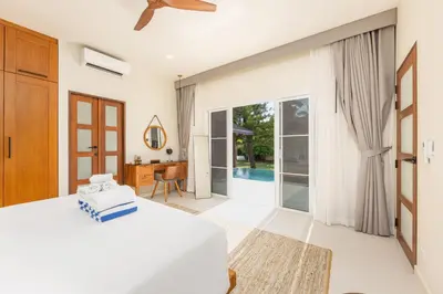 a bedroom with a bed and a sliding glass door at Villa Emilia Private Pool Naiharn in Rawai Beach