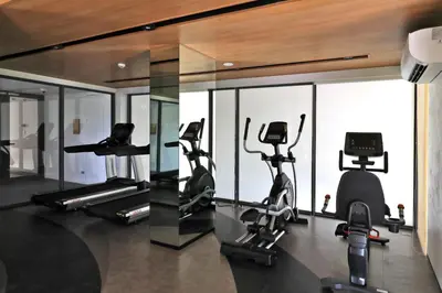 a gym with several treadmills and elliptical machines at 2 bdr Apartments Laguna Beachside 50m from Bangtao Beach in Bang Tao Beach