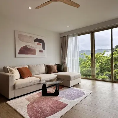 a living room with a couch and a table at 1 bdr Mountain View Apartment 50 m from Bangtao Beach in Bang Tao Beach
