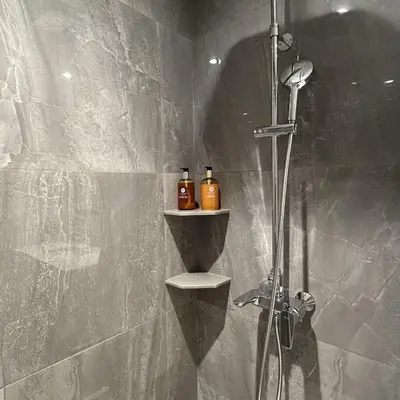 a bathroom with a shower with a shelf and a shower at 1 bdr Mountain View Apartment 50 m from Bangtao Beach in Bang Tao Beach