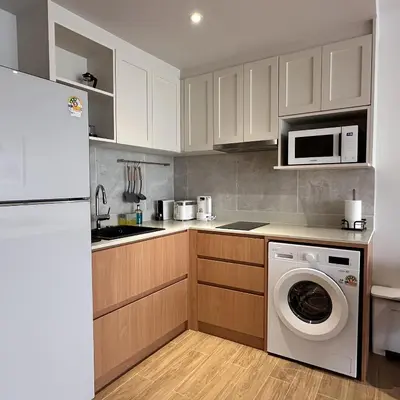 a kitchen with a washing machine and a microwave at 1 bdr Mountain View Apartment 50 m from Bangtao Beach in Bang Tao Beach