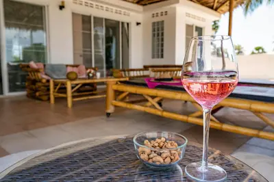 a glass of wine sitting on top of a table at Phuket Arkadia Home in Nai Harn Beach