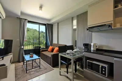 a living room with a couch and a table at 6th avenue surin in Surin Beach