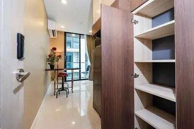 a hallway with a door leading into a room with a table at Tropical Stay at Apartment B603 in VV Patong in Patong Beach