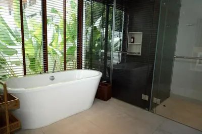a bathroom with a white tub and a glass shower at Villa Altessa 3BR Modern Loft II Botanica in Ban Pak Lak