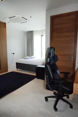 a bedroom with a bed and a black office chair at Villa Altessa 3BR Modern Loft II Botanica in Ban Pak Lak