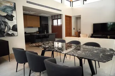 a dining room and kitchen with a table and chairs at Villa Altessa 3BR Modern Loft II Botanica in Ban Pak Lak