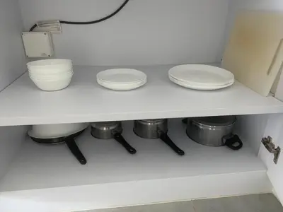 two plates and bowls on a shelf in a kitchen at Bangtao Beach Walk Villa by Taan Residence in Bang Tao Beach