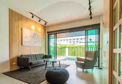 a living room with a couch and chairs and a table at Bangtao Beach Walk Villa by Taan Residence in Bang Tao Beach