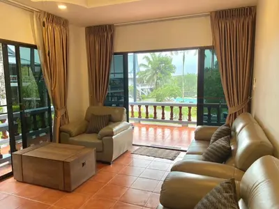 a living room with a couch and chairs and a balcony at The Vintage Kamala in Kamala Beach