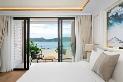 a bedroom with a bed and a view of the ocean at The Cyan at Patong Hotel in Patong Beach
