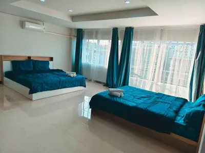 a bedroom with two beds and a large window at Central House Phuket in Phuket Town