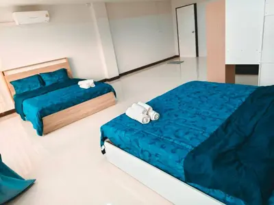 a bedroom with two beds with blue sheets and towels at Central House Phuket in Phuket Town