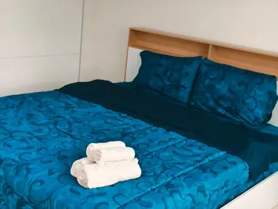 two towels on a bed with blue sheets at Central House Phuket in Phuket Town