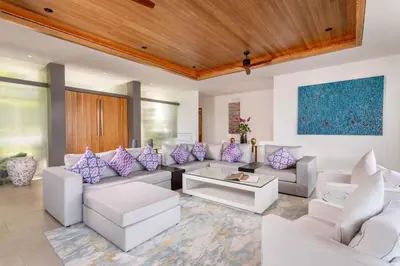 a living room with white furniture and purple pillows at Villa Narissa in Kamala Beach