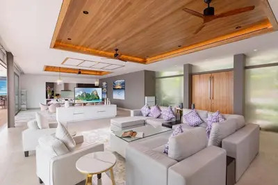 a living room with white couches and a kitchen at Villa Narissa in Kamala Beach