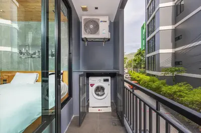 a balcony with a washing machine in a building at Relife Sol 2 min to Nai Harn beach by TropicLook in Rawai Beach