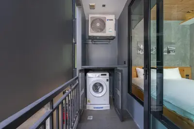 a small room with a washing machine and a bed at Relife Zen 2 min to Nai Harn beach in Rawai Beach