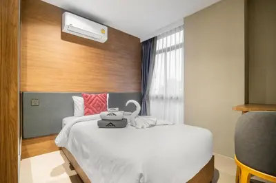 a hotel room with a bed with a swan on it at Stylish Beachfront Two-Bedroom Flat in Nai Thon Beach