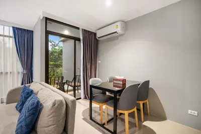 a living room with a table and a couch at Stylish Beachfront Two-Bedroom Flat in Nai Thon Beach