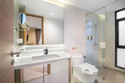 a bathroom with a sink and a toilet and a mirror at Stylish Beachfront Two-Bedroom Flat in Nai Thon Beach
