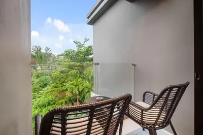two chairs and a table on a balcony at Stylish Beachfront Two-Bedroom Flat in Nai Thon Beach