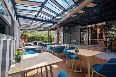 a restaurant with wooden tables and blue chairs at Stylish Beachfront Two-Bedroom Flat in Nai Thon Beach