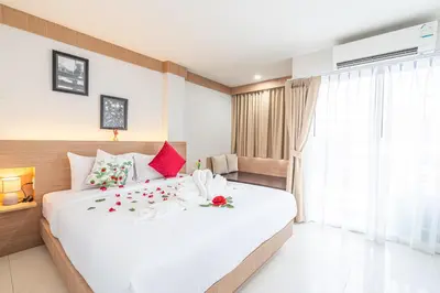 a bedroom with a large white bed with flowers on it at Seaside Patong House - Newly Open in Patong Beach