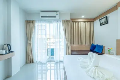 a bedroom with a large white bed and a window at Seaside Patong House - Newly Open in Patong Beach