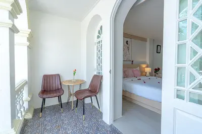 a bedroom with a bed and a table and two chairs at Seaside Patong House - Newly Open in Patong Beach