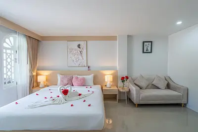 a bedroom with a large white bed with roses on it at Seaside Patong House - Newly Open in Patong Beach