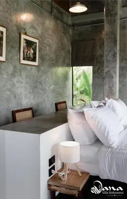 a bedroom with a bed and a table with pillows at Nana Villa in Ko Yao Noi