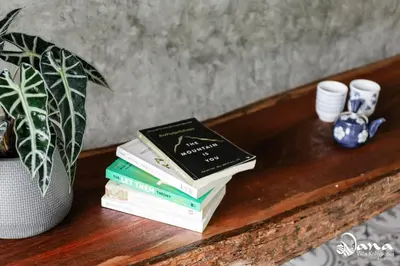 a stack of books on a table with a potted plant at Nana Villa in Ko Yao Noi