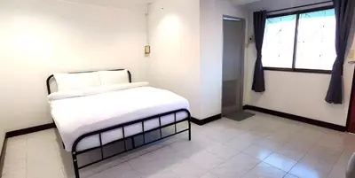 a bedroom with a bed with white sheets and a window at XX Go Inn Phuket Patong Beach - ป่าตองบีช in Patong Beach