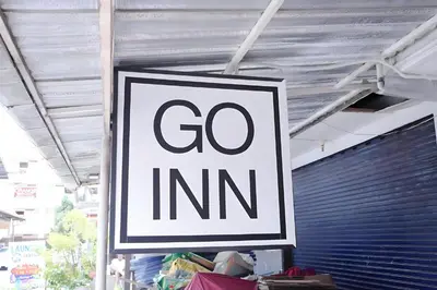 a sign that says go inn hanging from a ceiling at XX Go Inn Phuket Patong Beach - ป่าตองบีช in Patong Beach