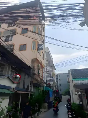a city street with buildings and people on motorcycles at xx BAO Patong Beach Phuket - เบา ป่าตองบีช in Patong Beach