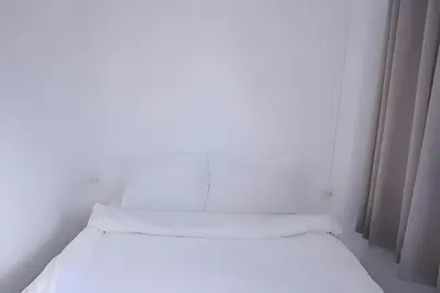 two beds in a white room with curtains at xx BAO Patong Beach Phuket - เบา ป่าตองบีช in Patong Beach