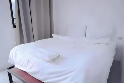 a white bed with white sheets and pillows at xx BAO Patong Beach Phuket - เบา ป่าตองบีช in Patong Beach