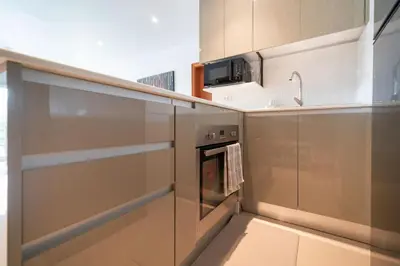 a kitchen with stainless steel appliances and a microwave at Stunning Lake View One Bedroom in Laguna Phuket