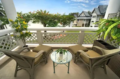 a porch with chairs and a glass table on a balcony at Stunning Lake View One Bedroom in Laguna Phuket