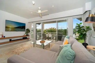 a living room with a couch and a table at Stunning Lake View One Bedroom in Laguna Phuket