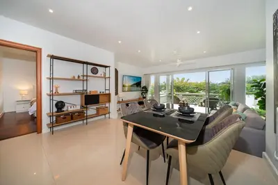 a living room with a table and a couch at Stunning Lake View One Bedroom in Laguna Phuket