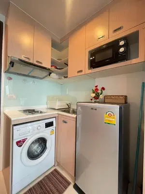 a kitchen with a washing machine and a microwave at Sabai Stay in Patong Beach